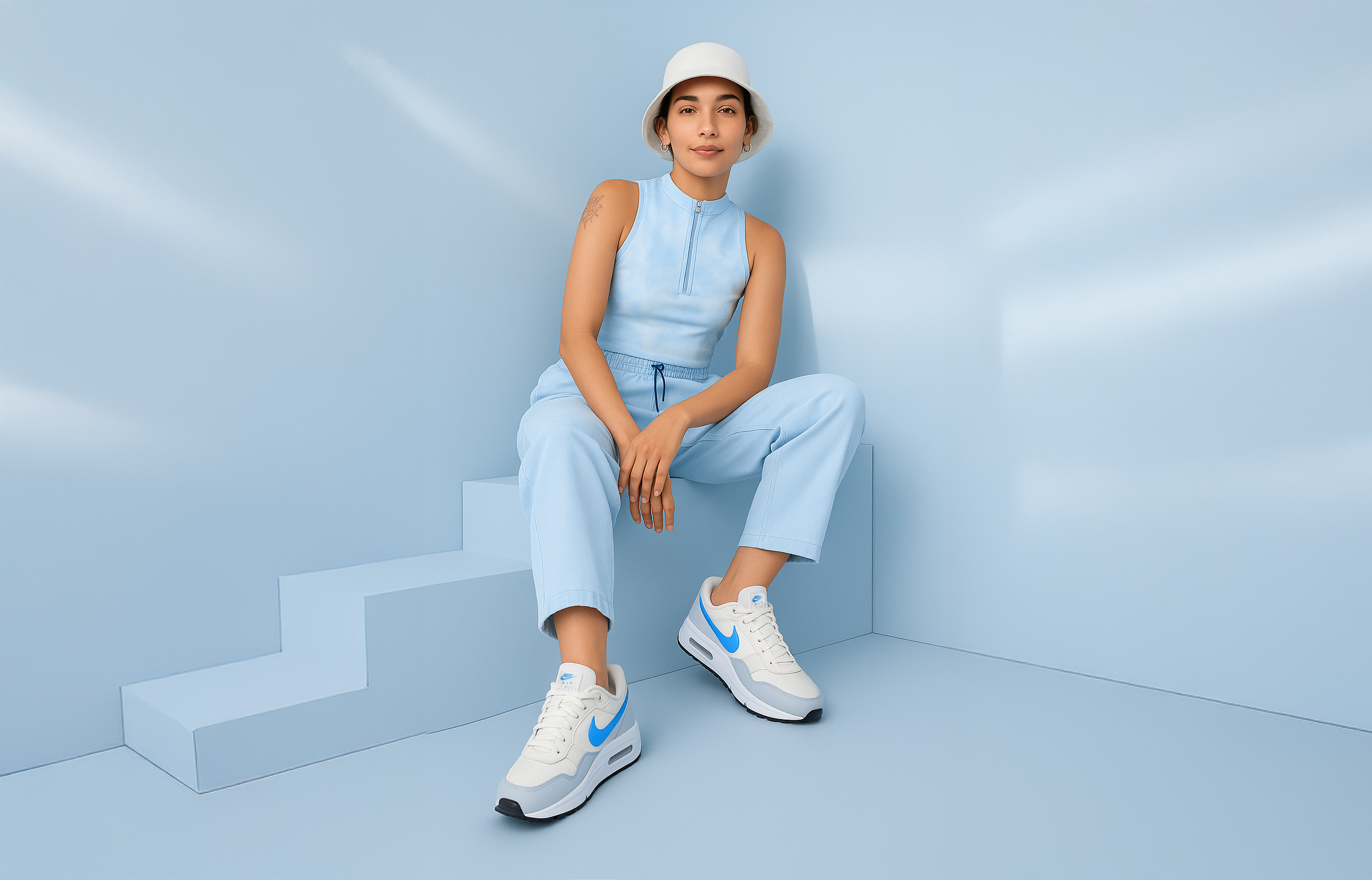 Mujer sentada con zapatillas Nike Air Max blancas y azules